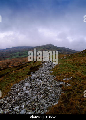 Pen y Gaer Iron Age hillfort, Conwy, Wales: view WNW along the three southern ramparts (stone, earthen banks and ditches) to the peak of Penygader. Stock Photo