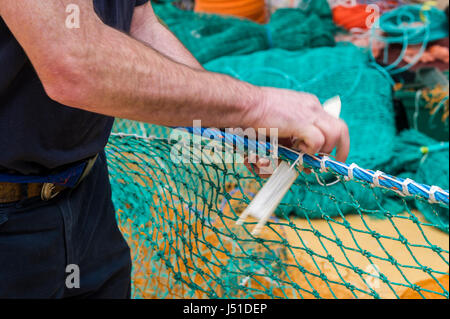 Fishing net maker demonstrates his craft in his shed in Ireland with copy space. Stock Photo