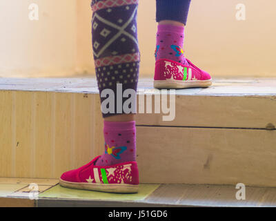 The girl in colorful shoes climbs the stairs Stock Photo