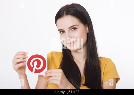 KIEV, UKRAINE - AUGUST 22, 2016: Woman hands holding Pinterest icon printed paper. Is photo sharing website. Stock Photo