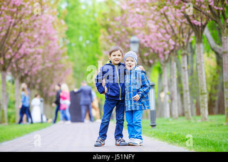 Young boys smiling while standing on lane in spring park Stock Photo