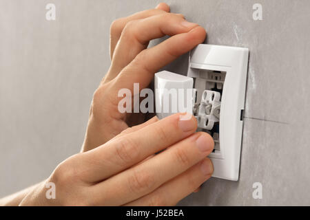 hands of electrician installing light switch on the wall Stock Photo