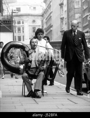 Professional serpent player Andrew van der Beek playing ‘The Anaconda’ outside Sotheby's in London August 1986. The instrument is the only known original example of a contra-bass serpent made by the brothers, Joseph and Richard Wood of Upper Heaton, Yorkshire, circa 1840.  Stock Photo