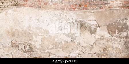 Old empty dirty plaster wall with cracked structure as background. Stock Photo