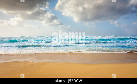 A wide view of large, powerful blue waves rolling in to Sunset Beach on a warm summer day on the North Shore of Oahu, Hawaii. Stock Photo