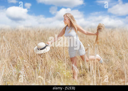 Happy Young woman in a wheat field Stock Photo