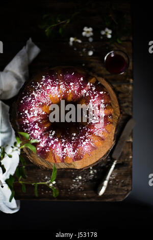 Bundt cake with blackberry glaze and white chocolate flakes Stock Photo