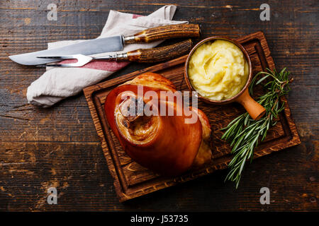 Roasted pork knuckle eisbein with mashed potatoes on wooden cutting board Stock Photo