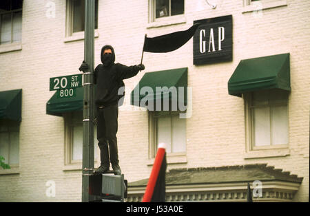 Black Bloc Anarchist holding black flag at the GAP. Protesters block streets and protest against banks and globalization during the IMF and World Bank protests Monday, April 17, 2000 in Washington, D.C. Stock Photo