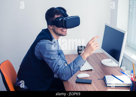 Young businessman putting on vr glasses and smiling Stock Photo