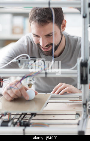 Young designer engineer using a 3D printer in the laboratory and studying a product prototype, technology and innovation concept Stock Photo