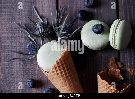 Homemade macaroons among thistle and blueberries Stock Photo