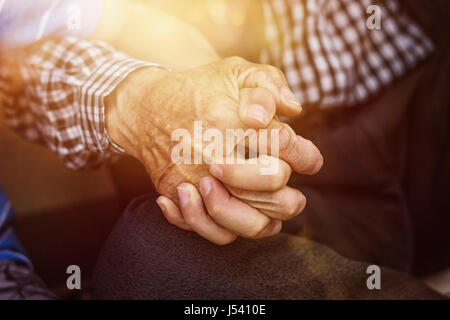 nephew holding strong grandfather's hand Stock Photo