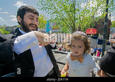 5.14.2017 A young orthodox Jewish boy gets his first haircut at age three at the Lag B'Omer parade in Crown Heights, Brooklyn, New York City Stock Photo