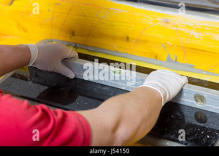 placing a spirit level by hands of handyman on natural stone tile Stock Photo