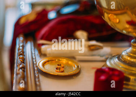 Two golden wedding rings in ceremonial bown on church altar Stock Photo