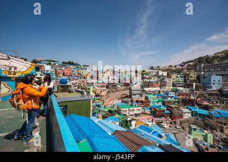 A tourist taking photos of brightly painted houses in Gamcheon Culture Village, Busan Gwanyeoksi, South Korea Stock Photo