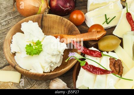 Refreshments from different types of cheese. Healthy breakfast of dairy products. Sliced cheeses on a wooden table Stock Photo