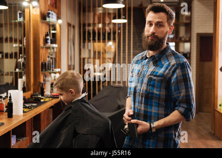 Nice good looking barber holding a comb Stock Photo