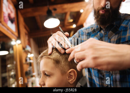 Good looking young barber using scissors Stock Photo