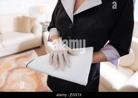 Close up of a duster in hands of the hotel maid Stock Photo