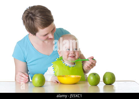 Mother spoon-feeding her baby isolated on white Stock Photo
