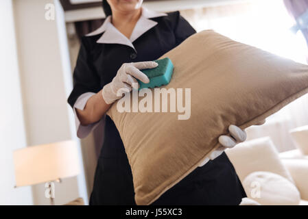 Cushion being in the hands of a professional chambermaid Stock Photo