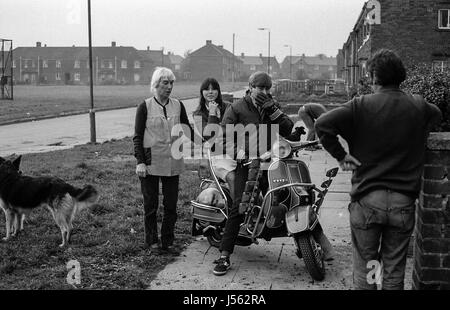 Brafferton Arbor, Buttershaw Estate, Bradford, West Yorkshire, UK. A sprawling local authority 1950's council housing scheme. Black and white images from 1982 portray the gritty surroundings of a typical northern England working class sink estate. Family group and a MOD on with a Vespa scooter. Stock Photo