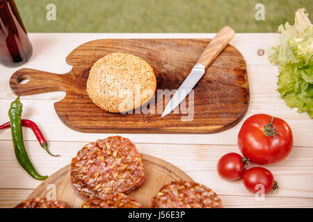 ingredients for hamburgers on table, meat, tomatoes and peppers outdoors Stock Photo