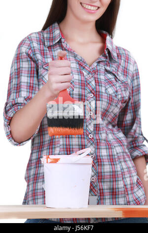 Portrait of young female builder in helmet painting on white Stock Photo