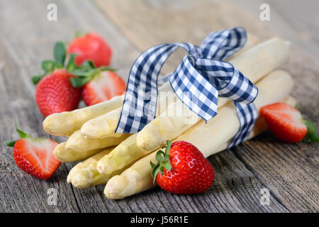 White asparagus from Germany with strawberries on a wooden table Stock Photo
