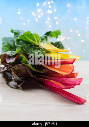 Stack of Rainbow Chard Leaves on light wooden table top Stock Photo