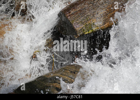 Water flowing through granite rocks in mountain rapids Stock Photo