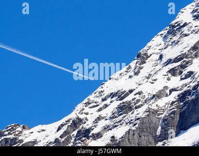 Switzerland vapour trail from an airliner over the Eiger mountain from Grindelwald in the Burnese Oberland Stock Photo