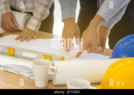 Business teamwork working on blueprint, engineering tools, soft light effect, selective focus Stock Photo