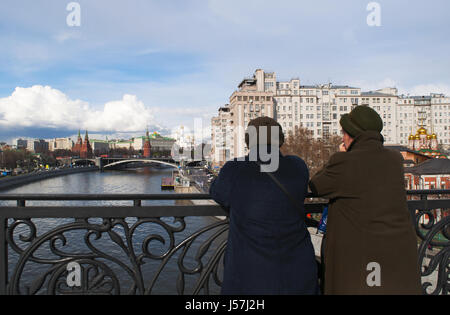 Moscow: old Russian women looking the skyline of Moscow with view of the fortified complex of the Kremlin from the Patriarch Bridge on Moskva River Stock Photo