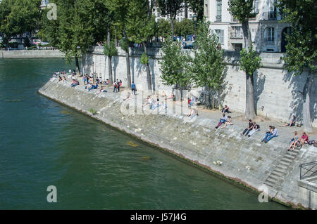 People relaxing on the banks of the Seine River, Paris, France Stock Photo