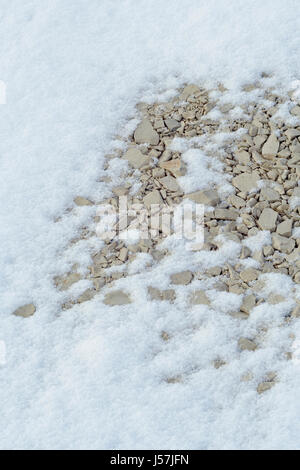 Yellowish stones surrounded by delicate snow flakes at the winter. Stock Photo