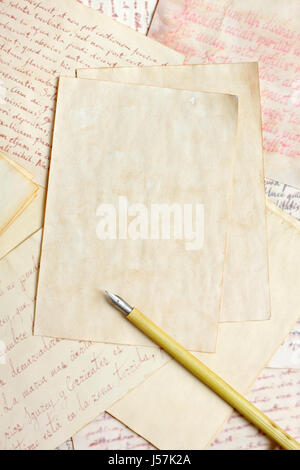 Aged empty paper sheets with vintage nib pen over antique handwritings Stock Photo