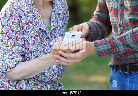 Grandmother and grandson using a white smartphone Stock Photo