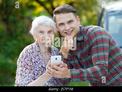 Grandmother and grandson using a white smartphone Stock Photo