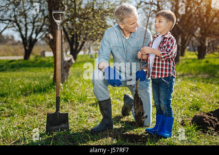 Grandfather with his grandson working in garden Stock Photo