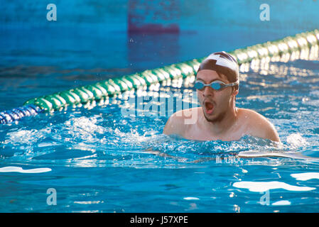 Man swim in pool lane on sunny day light. Man doing swimming sport Stock Photo