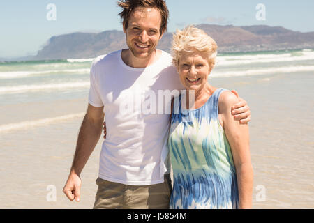 Portrait of cheerful mother and son standing on shore at beach Stock Photo