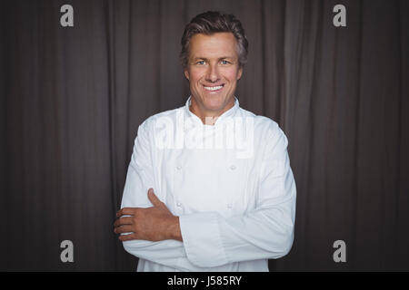 Portrait of handsome chef standing with arms crossed in restaurant Stock Photo