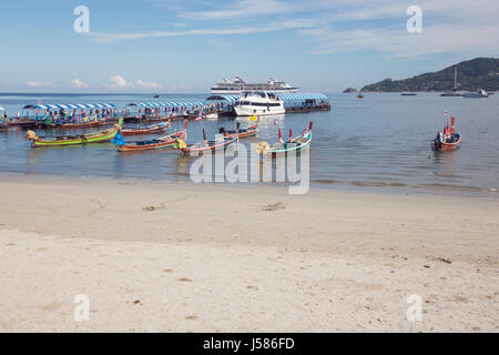 Editorial: PATONG BEACH, PHUKET ISLAND, THAILAND, April 4, 2017 - Cruise ship tourists debarking on Patong Beach with longtail boats waiting on the se Stock Photo