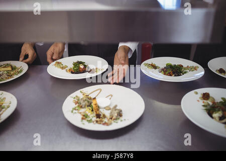 Male chef keeping appetizer plate ready on the order station at restaurant Stock Photo