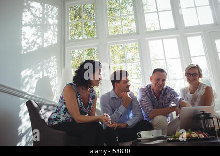 Friends using laptop while having breakfast in restaurant Stock Photo