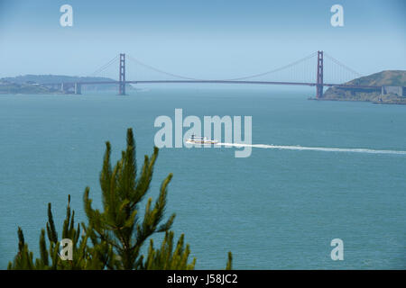 Blue And Gold Fleet Ferry Steams Past The Golden Gate Bridge, San Francisco. Stock Photo