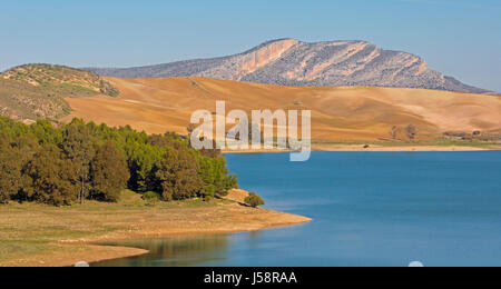 View across Guadalhorce dam, Malaga Province, Andalusia, Spain, to farmland beyond. Embalse de Conde de Guadalorce. Stock Photo